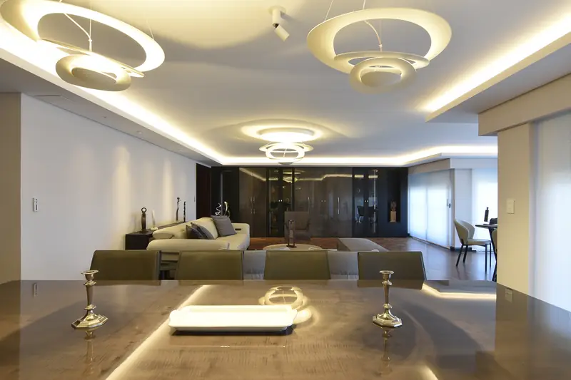 Vista desde la mesa del comedor hacia el living, con el techo rebajado y su luz indirecta