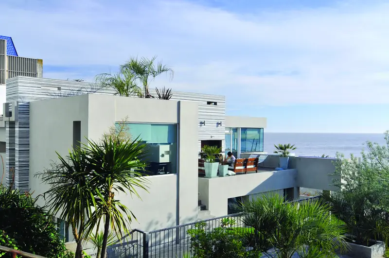 La casa entre palmeras sobre la rambla, con terrazas abiertas al río