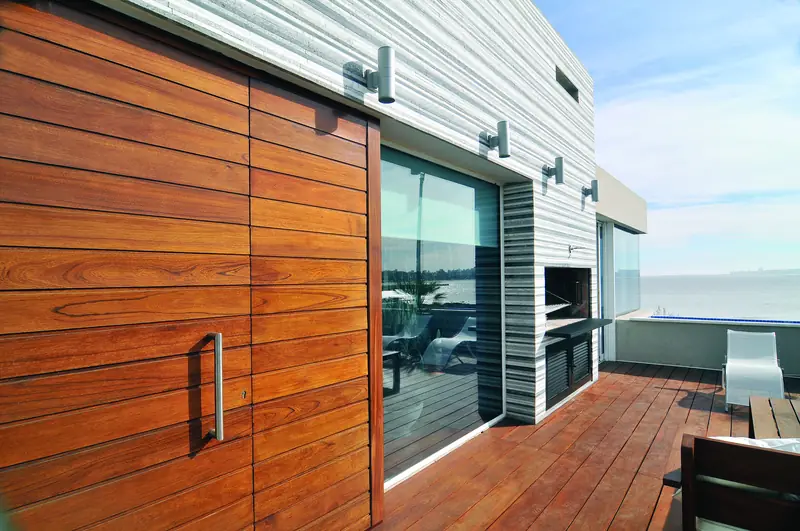 Grandes paneles corredizos de madera junto a la terraza